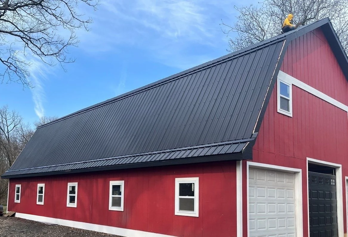 Dark metal panel roof installed on a red barn-style building in Naperville, Illinois