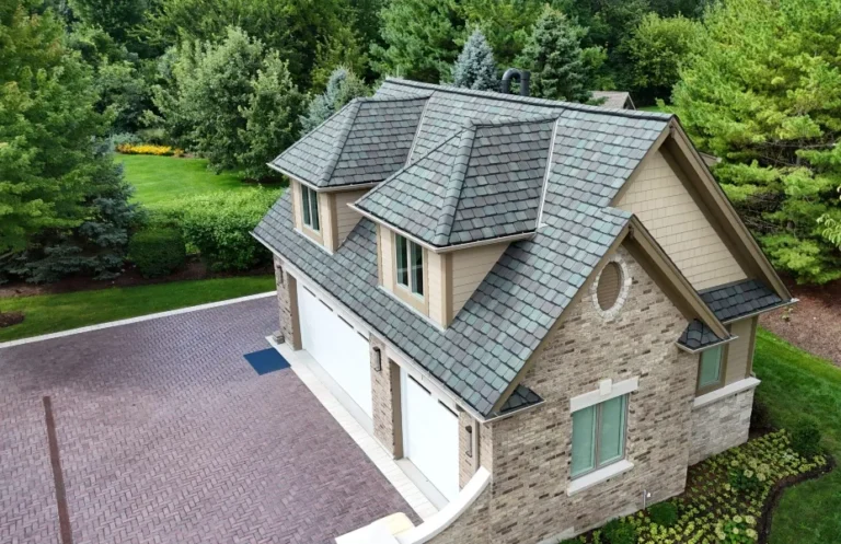 Detached garage with dormers and a blue, green and plum slate roof over a herringbone paver driveway in Naperville, IL