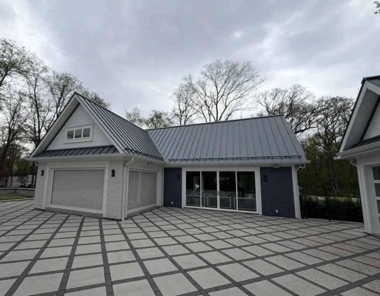 Detached garage and pool house with a gray standing seam metal roof and white trim in Plano, IL